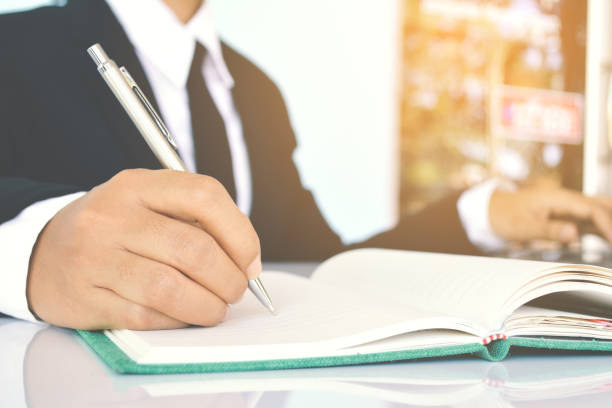 istock Midsection Of Businessman Writing In Book 726889301