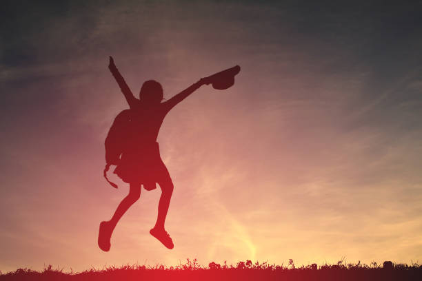 istock Silhouette Backpack Girl Jumping With Arms Raised On Field During Sunset 727138817