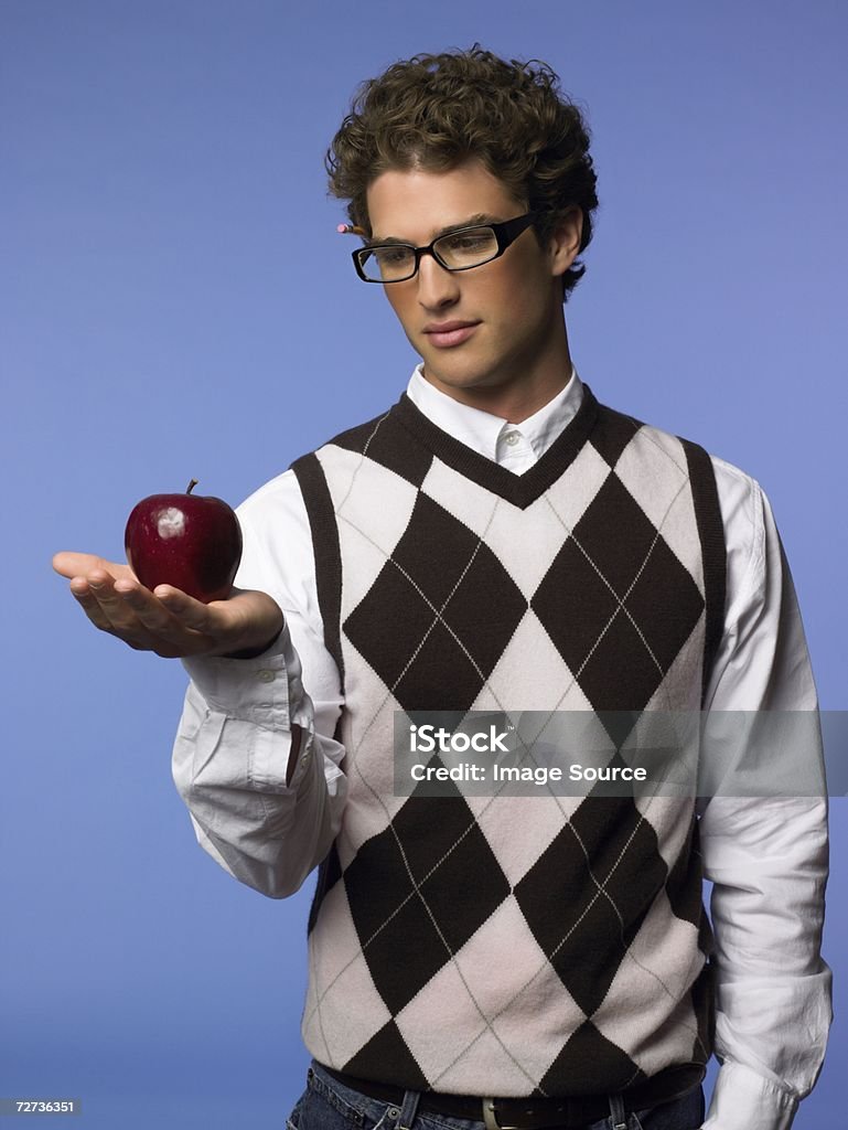 Joven sosteniendo una manzana - Foto de stock de Alimento libre de derechos