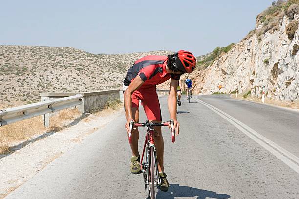 cyclist looking over shoulder - cycling vest 뉴스 사진 이미지