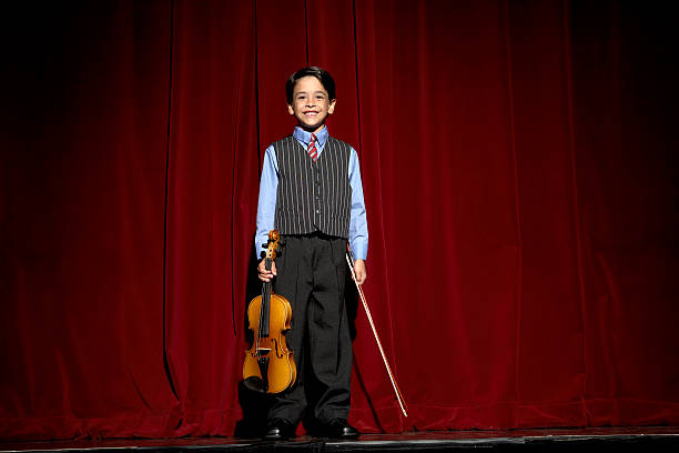 chłopiec (6-7), stojąc na scenie z skrzypce - chi chi zdjęcia i obrazy z banku zdjęć