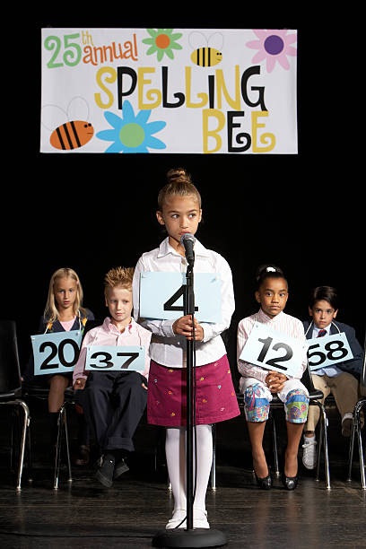 Girl (6-7) performing at spelling bee competition  spelling bee stock pictures, royalty-free photos & images