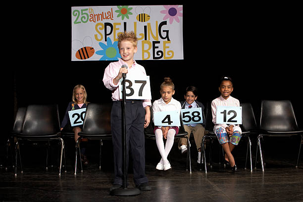 Boy (8-9) performing at spelling bee competition  spelling bee stock pictures, royalty-free photos & images
