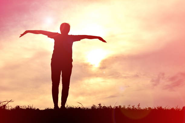 istock Silhouette Woman Standing With Arms Outstretched On Field During Sunset 728874523