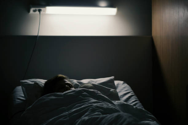 istock Man Sleeping On Bed In Illuminated Bedroom 728879329