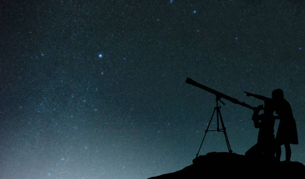 istock Silhouette Friends Using Telescope Against Star Field At Night 730192135
