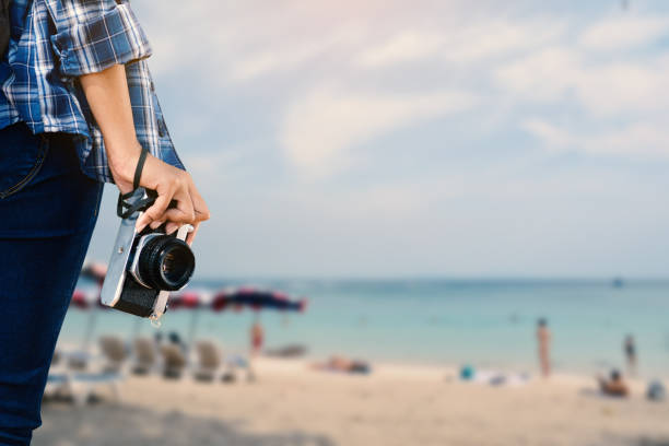 istock Midsection Of Woman Holding Camera On Beach 730259525