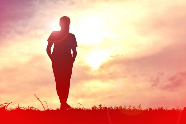 istock Silhouette Woman Standing On Field Against Sky During Sunset 730288455