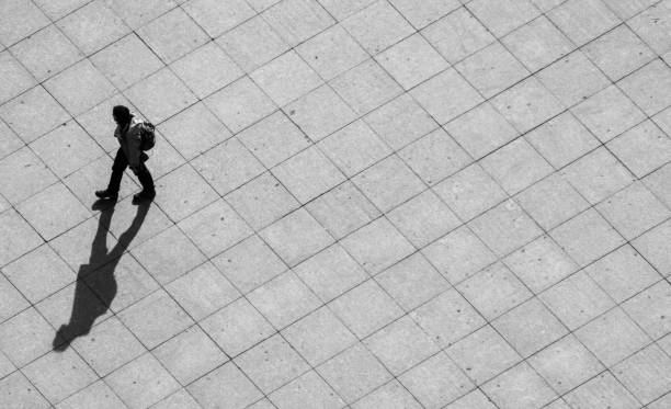 istock High Angle View Of Man Walking On Footpath During Sunny Day 730289603