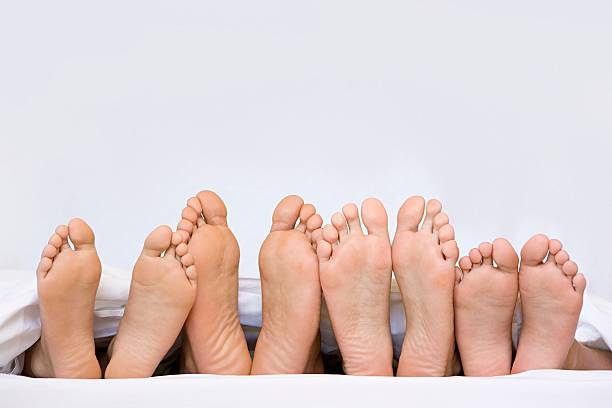 A row of bare feet  bed human foot couple two parent family stock pictures, royalty-free photos & images