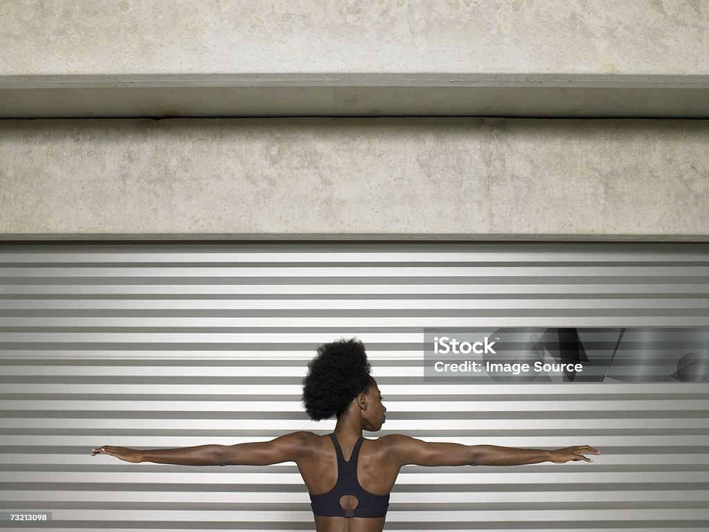 Nero giovane atleta femmina lo stretching le sue braccia - Foto stock royalty-free di Abbigliamento