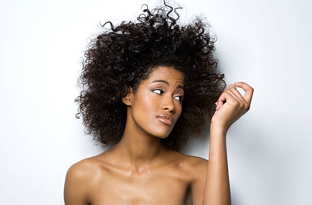 young woman looking at her hair, primer plano - mano en el cabello fotografías e imágenes de stock
