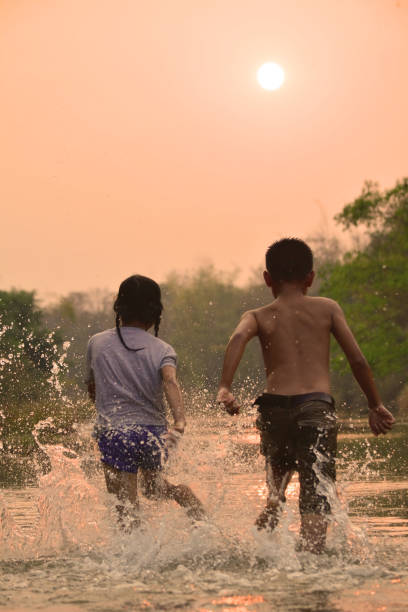 istock Children Playing In River Against Sky At Dusk 732740621