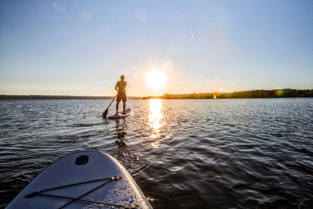 istock Man Paddleboarding In Sea Against Sky During Sunset 733478237