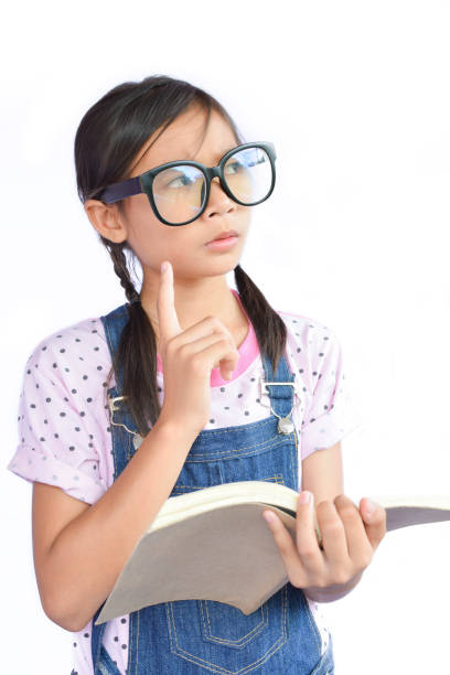 istock Thoughtful Girl Holding Book While Standing Against White Background 733520053