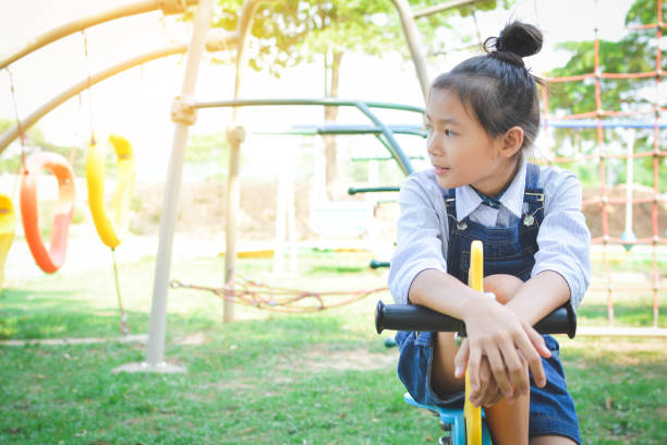 istock Thoughtful Girl Sitting On Spring Ride At Park 733525747