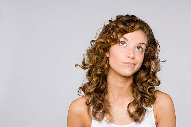 frau suchen verwirrt - hairstyle long hair curly hair women stock-fotos und bilder