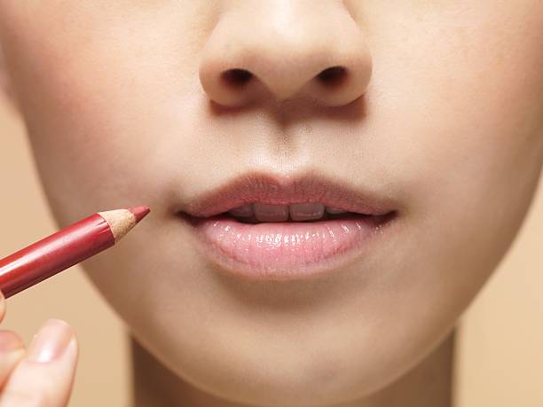 mujer aplicar delineador de labios - lip liner fotografías e imágenes de stock