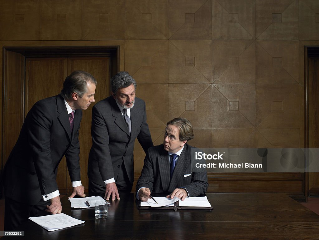 Dojrzali mężczyźni Patrząc na dokumenty na Koniec tabeli - Zbiór zdjęć royalty-free (Sala posiedzeń)