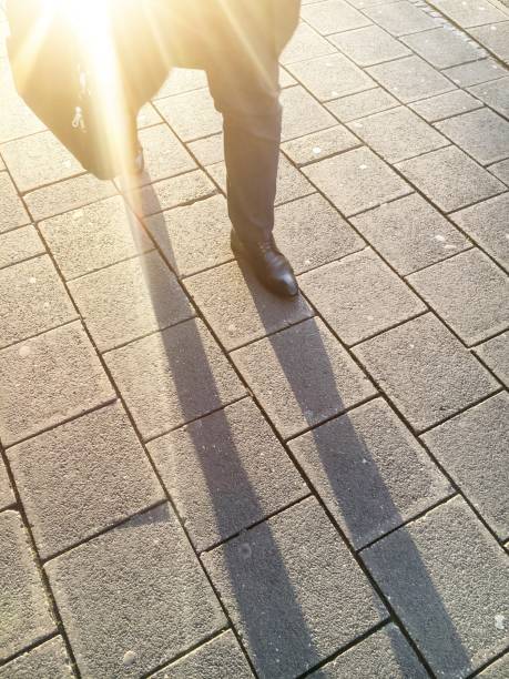 istock Low Section Of Businessman Walking On Footpath 735964707