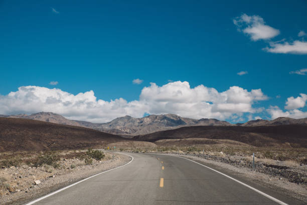 estrada vazia por montanhas contra o céu azul - 5895 - fotografias e filmes do acervo