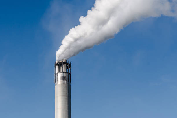 istock Smoke Emitting From Chimney Against Clear Blue Sky 736514031