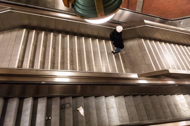istock High Angle View Of Woman Moving Down On Steps By Escalator At Subway Station 736514957