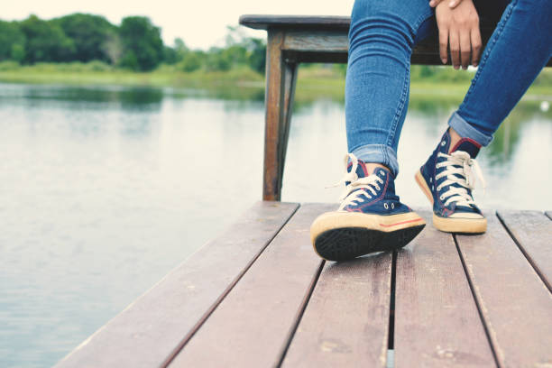 istock Low Section Of Man Sitting By Lake 736518303