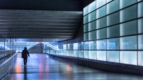 istock Rear View Of Man Walking In Illuminated Tunnel 736519259