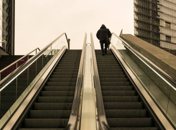 istock Low Angle View Of Man On Escalator Against Sky 736840845