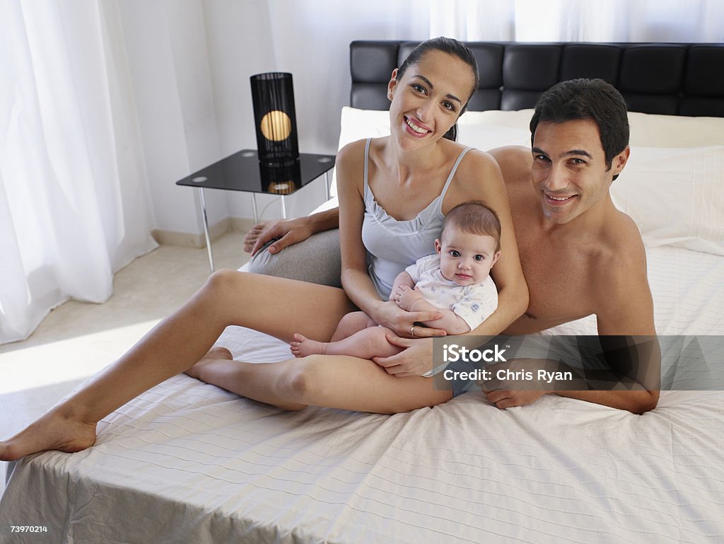 Paar Leg dich auf einem Bett mit baby-Tochter - Lizenzfrei 2-5 Monate Stock-Foto