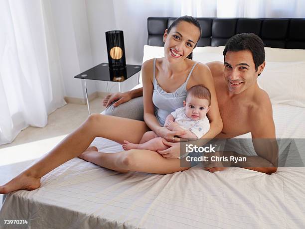 Paar Leg Dich Auf Einem Bett Mit Babytochter Stockfoto und mehr Bilder von 2-5 Monate - 2-5 Monate, 25-29 Jahre, 30-34 Jahre