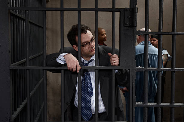 Four men in prison cell, one leaning against bars  exclusion group of people separation fish out of water stock pictures, royalty-free photos & images