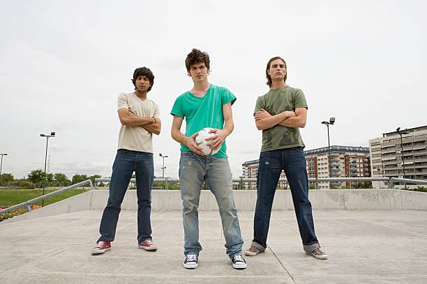 jeunes hommes avec joueur de football - three boys photos et images de collection