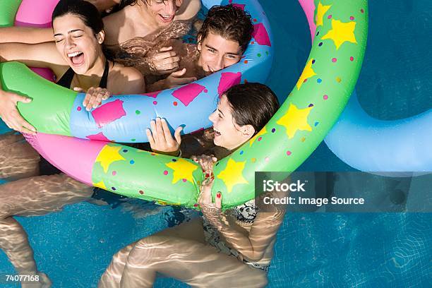 Friends Playing In Pool Stock Photo - Download Image Now - Swimming Pool, Teenager, Day
