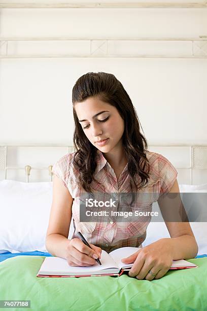 Teenage Girl Writing In Book - 1人のストックフォトや画像を多数ご用意 - 1人, カラー画像, クッション