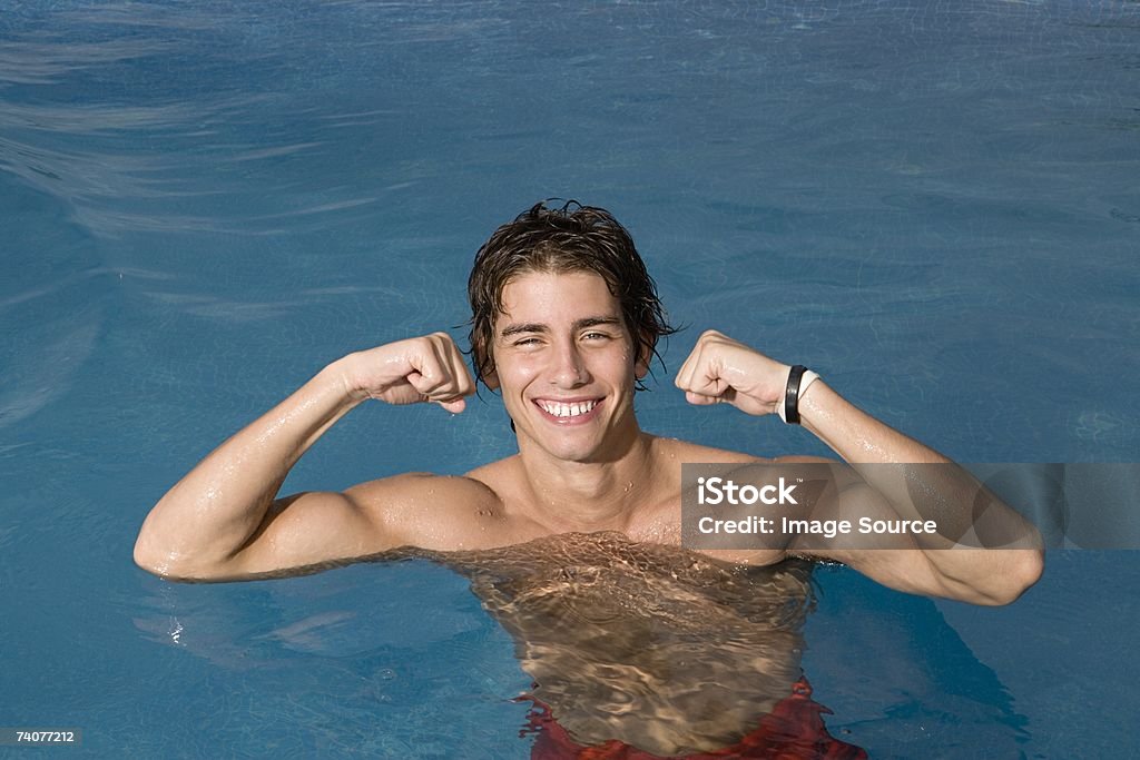 Teenage Boy Flexing Muscles Stock Photo - Download Image Now - Muscular  Build, Swimming Pool, Teenage Boys - iStock