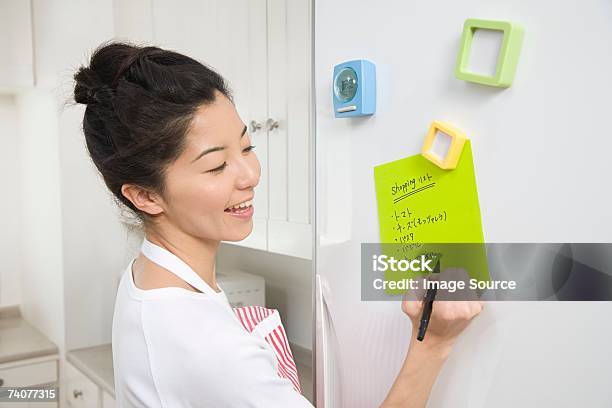 Woman Writing Shopping List Stock Photo - Download Image Now - Refrigerator, Shopping List, List