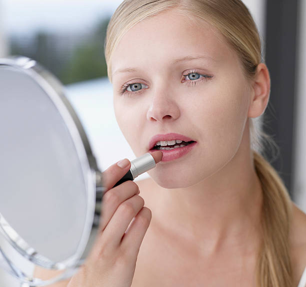 mulher aplicando batom no espelho - applying make up - fotografias e filmes do acervo