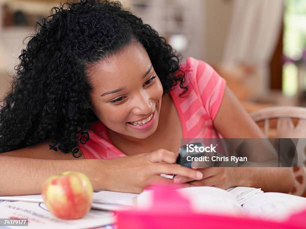 Teenagermädchen Sitzend Am Tisch Mit Handy Und Apple Stockfoto und mehr Bilder von Am Telefon