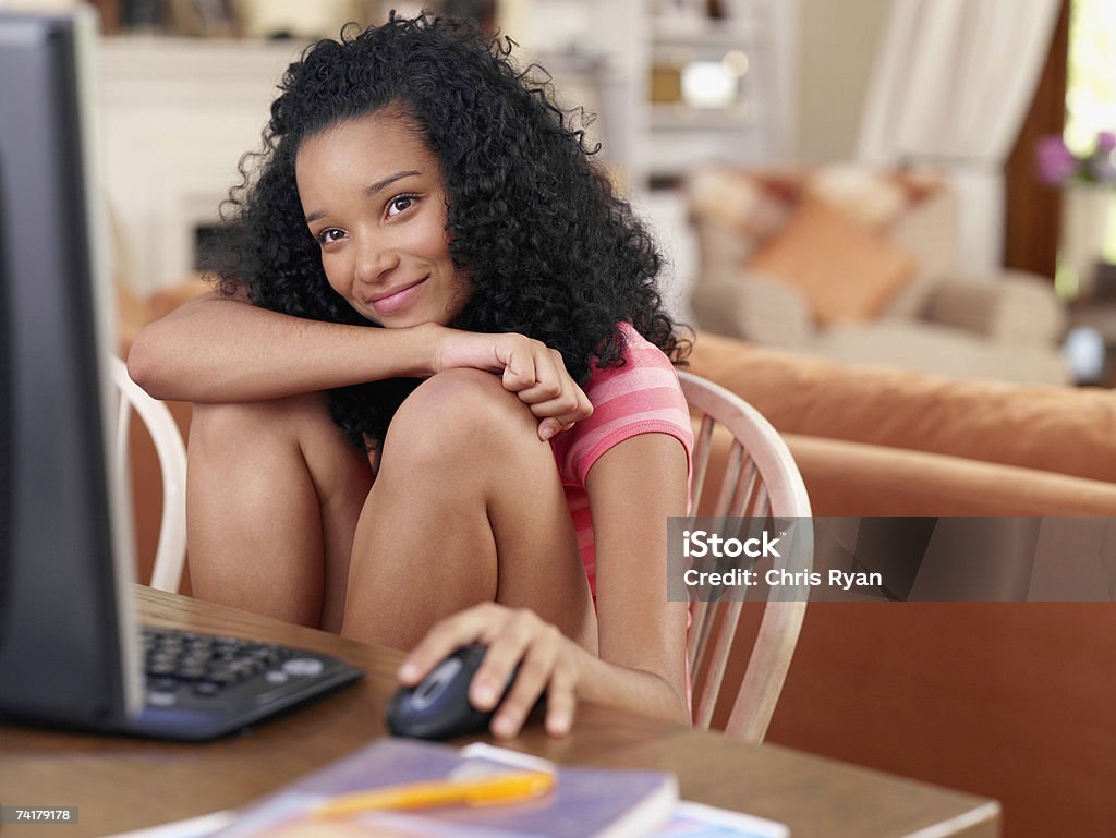 Jeune fille assise à table avec ordinateur - Photo de 14-15 ans libre de droits