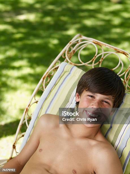 Niño Sonriente Relajante Al Aire Libre En Verano Foto de stock y más banco de imágenes de Acostado - Acostado, Chicos adolescentes, Hierba - Pasto