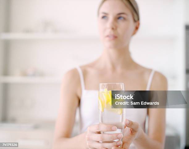 Mujer Agarrando Vaso De Agua De Limón Foto de stock y más banco de imágenes de Beber - Beber, Limón, Bebida