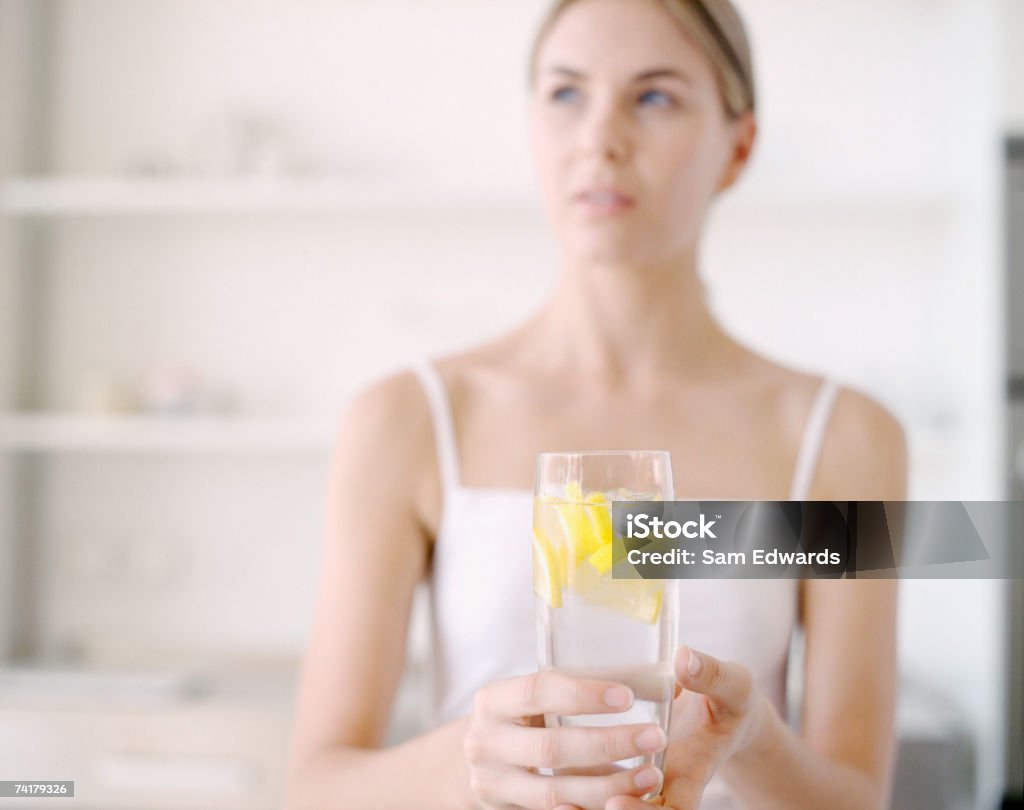 Mulher segurando um copo de água com limão - Foto de stock de Beber royalty-free