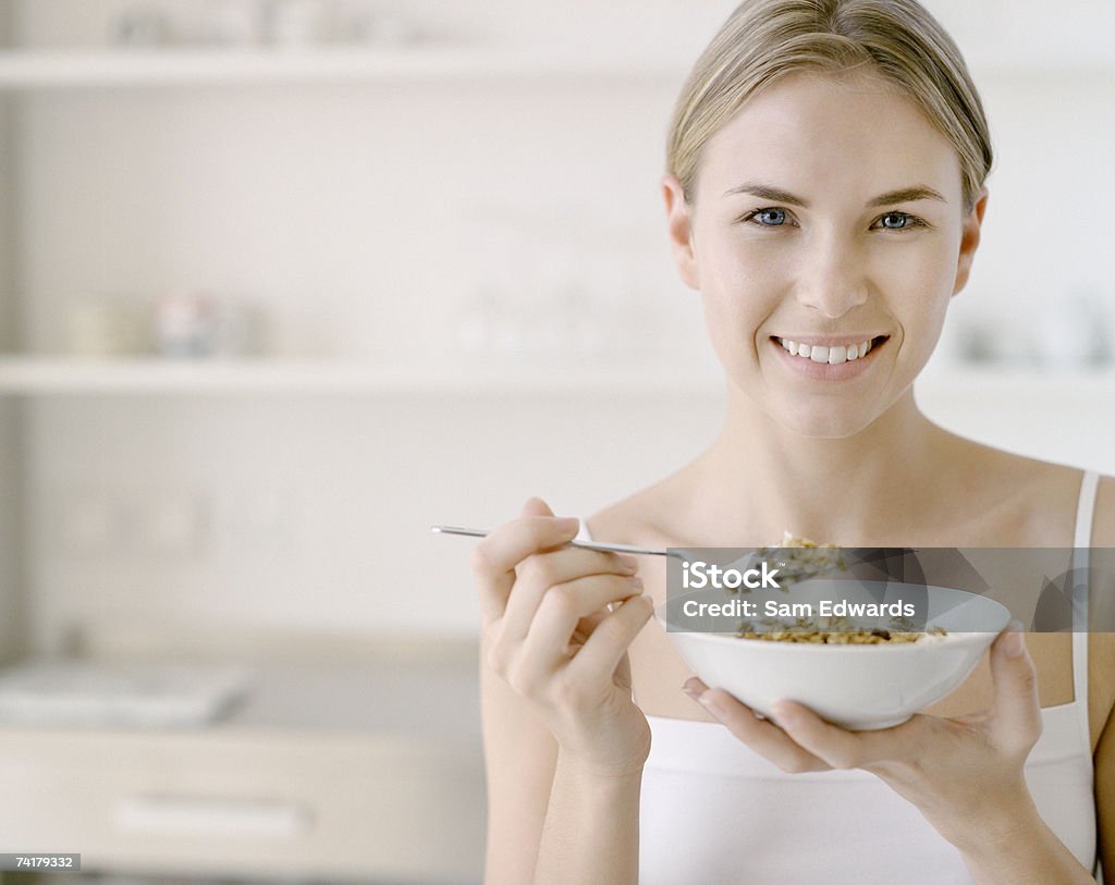 Donna con una ciotola di cereali - Foto stock royalty-free di Cereali da colazione