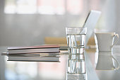 Close-up of glass with water on desk with laptop