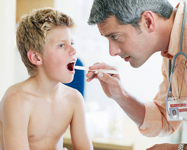 menino com masculino médico - doctor patient male tongue depressor imagens e fotografias de stock