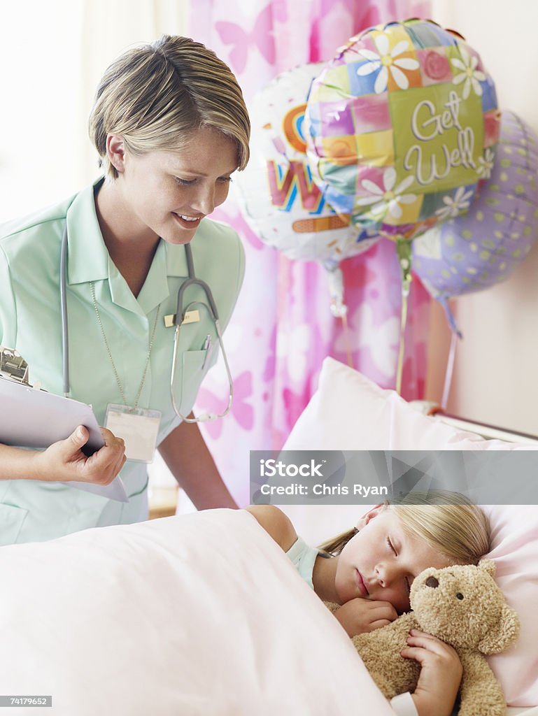 Niña durmiendo con Osito de peluche en el hospital con el personal de enfermería - Foto de stock de Hospital libre de derechos