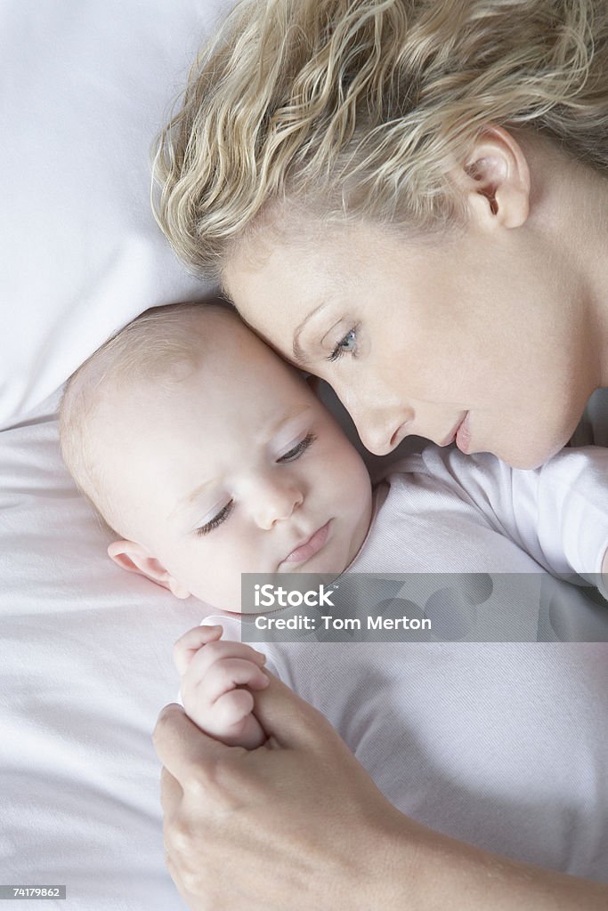 Mãe colocar na cama com bebê dormindo - Foto de stock de 30-34 Anos royalty-free