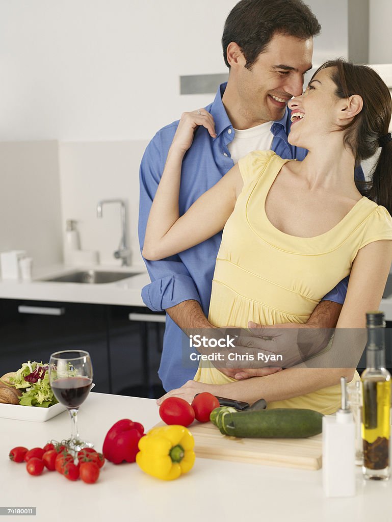 Мужчина и женщина, Обнимать на кухне с овощами и красное вино - Стоковые фото 25-29 лет роялти-фри
